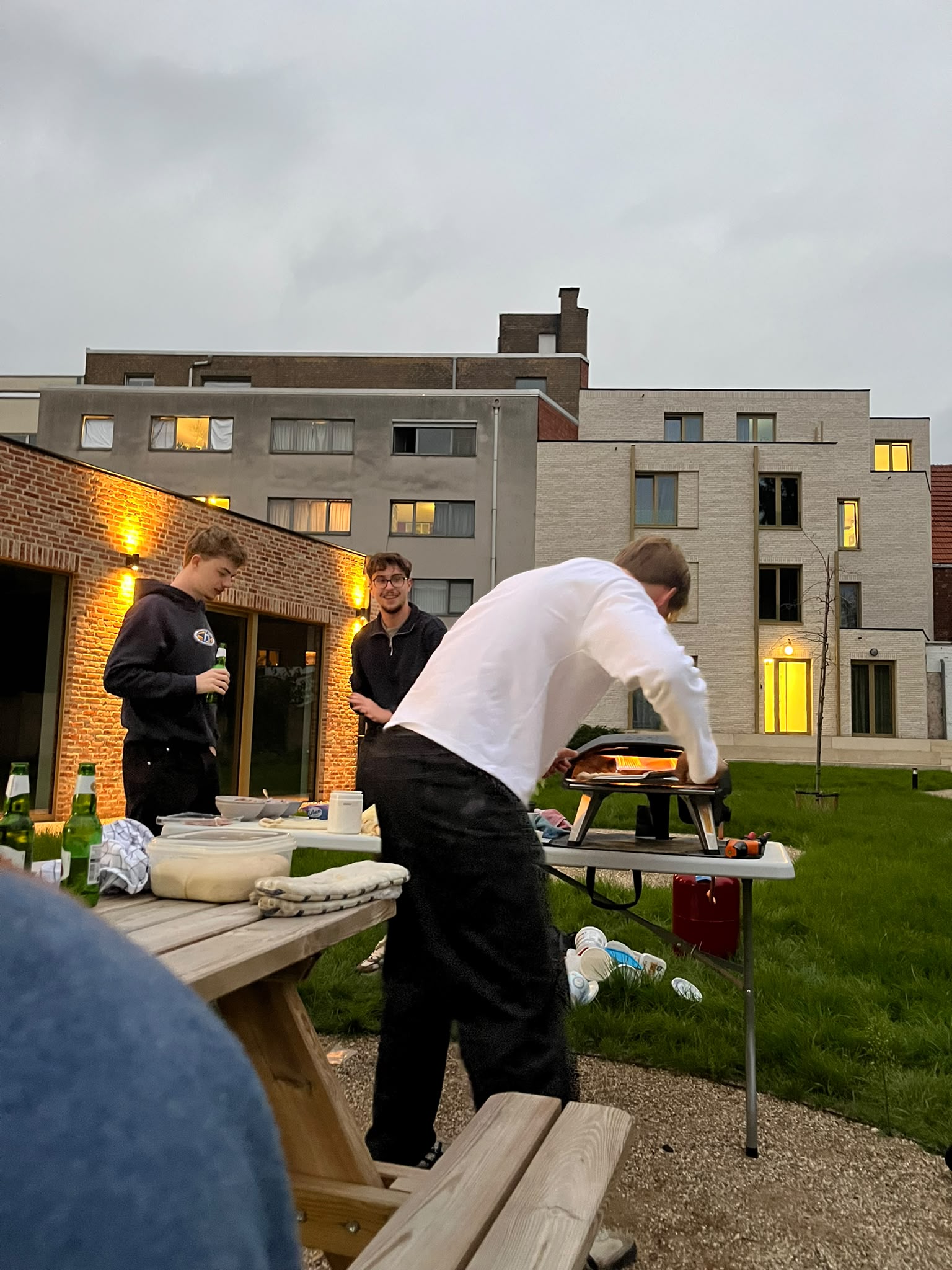 Adrian en Lukas bakken pizza met de Ooni-oven op het binnenplein